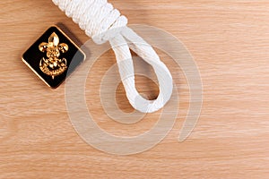 Orderliness white scout rope with vintage boy scouts badge on wooden table. photo