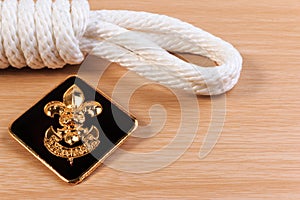 Orderliness white scout rope with vintage boy scouts badge on wooden table.