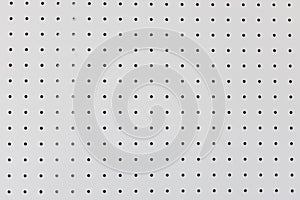 Orderly dot or holes rows and columns on white pegboard wall photo