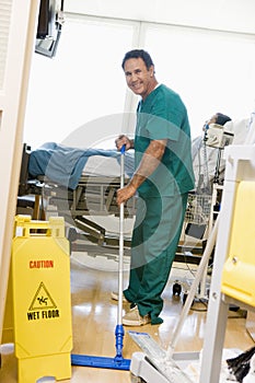 An Orderly Mopping The Floor In A Hospital