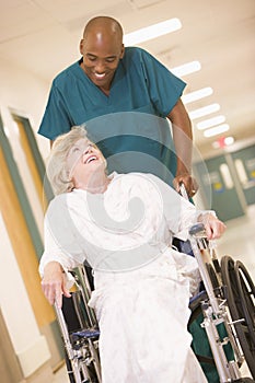 An Orderly Pushing A Senior Woman In A Wheelchair photo