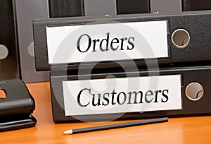 Orders and Customers - two binders with text in the office