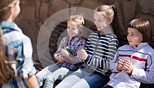 Ordinary children in the park on a bench in autumn