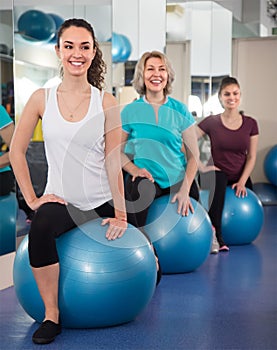 Ordinary different age women jumping on exercise ball