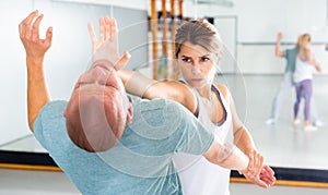 Ordinary female is fighting with trainer on the self-defense course for woman in club