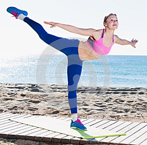 Ordinary girl stretching muscles on the sand