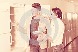 Ordinary happy couple looking at fridges