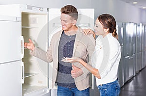 Ordinary happy couple looking at fridges