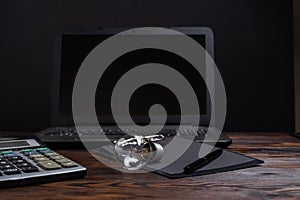 Ordinary incandescent lamp and office. Light bulb and calculator. Glass lamp on the table