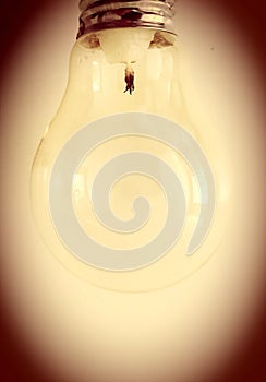 An ordinary light bulb with a candle inserted instead of wires as an indicator of the coming crisis in the World