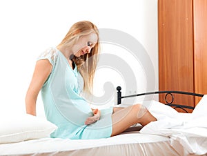 Ordinary long-haired pregnant blond waking up