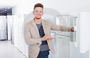 Ordinary male customer looking at modern fridges