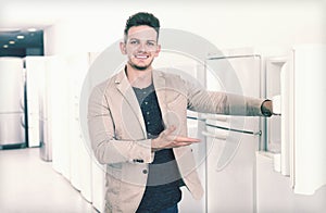Ordinary male customer looking at modern fridges