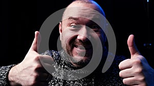 An ordinary man of forty years old laughs and holds an ok hand gesture on a dark background