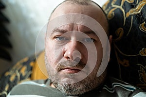 Ordinary middle aged man. The unshaven face of a man in his forties. Unhealthy appearance of the face, fatigue