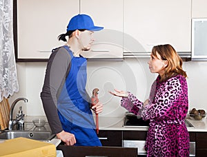 Ordinary plumber working at kitchen