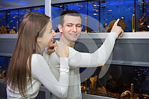 Ordinary positive smiling customers selecting tropical fish