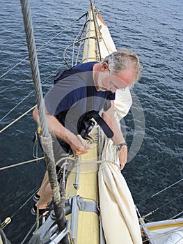 Seaman working aloft on tallship photo