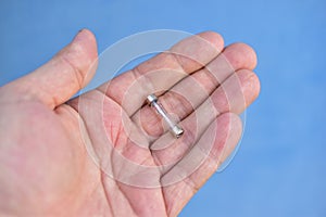 Ordinary wire fuse in a glass shell in the hand