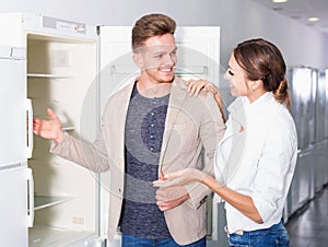 Ordinary young customers looking at fridges
