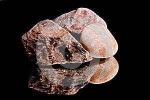 Ore from a diamond mine. isolated on black background with reflexion.