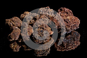 Ore from a diamond mine. isolated on black background with reflexion.