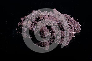 Ore from a diamond mine. isolated on black background with reflexion.