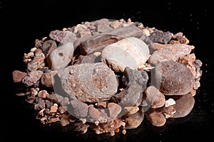 Ore from a diamond mine. isolated on black background with reflexion.