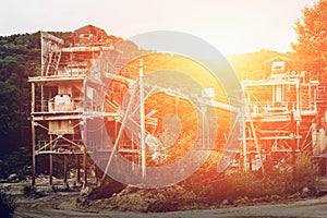 The ore processing plant or factory at the mining quarry in the sunset