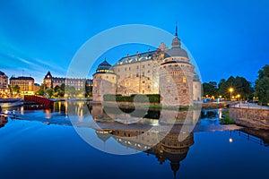 Orebro Castle reflecting in water in the evening, Sweden