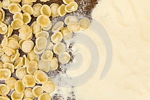 Orecchiette and durum wheat flour on a wooden table