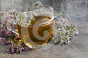 Oregano tea in a glass cup on a wooden background.Healthy drink,diet,alternative therapy