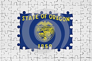 Oregon US state flag in frame of white puzzle pieces with missing central part