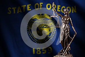 Oregon US state flag with statue of lady justice and judicial scales in dark room. Concept of judgement and punishment