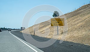 Highway interstate sign noting a truck escape ramp ahead, for runaway semi trucks going down a