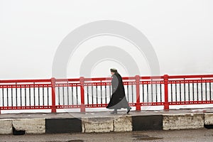 Orel, Russia - March 5, 2016: Woman quickly walking along bridge