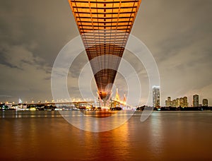 Oreng led light under the bridge over the river On a cloudy day in the sky. Bhumibol Bridge, Samut Prakan, Thailand