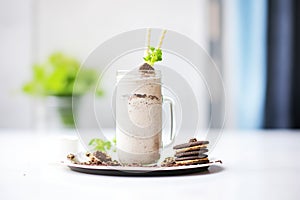 oreo milkshake with cookie crumbles, whole oreos on plate