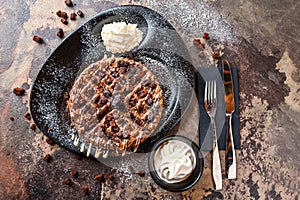 Oreos and Brownie Waffle with chocolate, whipped cream, knife and fork served in dish isolated on dark background top view cafe