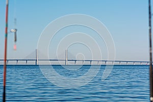 The Oresund bridge linking Denmark with Sweden. Blue sky and ocean. Fishing rods