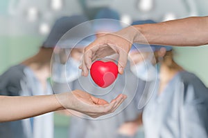 Organ donation concept. Hand giving heart. photo