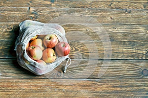 Organic apples in reusable eco friendly natural bag on the wooden background