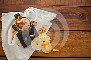 Organic assorted dried fruit snacks in glass jar on wooden background