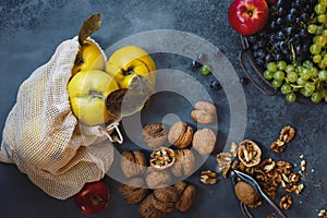 Organic Autumn Fruit And Nuts. Quinces, grapes, apples and walnuts on a table