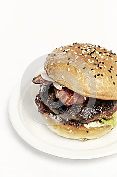 Organic beef burger with bacon on white table
