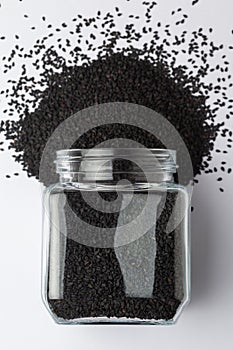 Organic Black Sesame seedsSesamum indicum or Black Til with shell, spilled and in a glass jar. photo