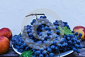 Organic blue grapes with peaches, prepared for the buffet table.on a white background