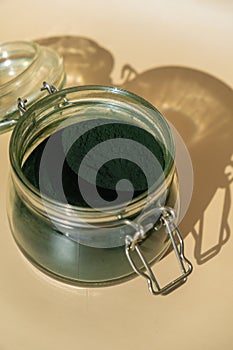 Organic blue-green algae spirulina powder food in glass jar. Health benefits of spirulina chlorella. Dietary supplement