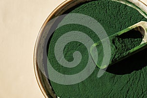 Organic blue-green algae spirulina powder food in plate with wooden spoon. Copy space for your text Health benefits of