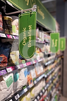 Organic Breakfast signage at the aisle of supermarket with defocused merchandise on shelf